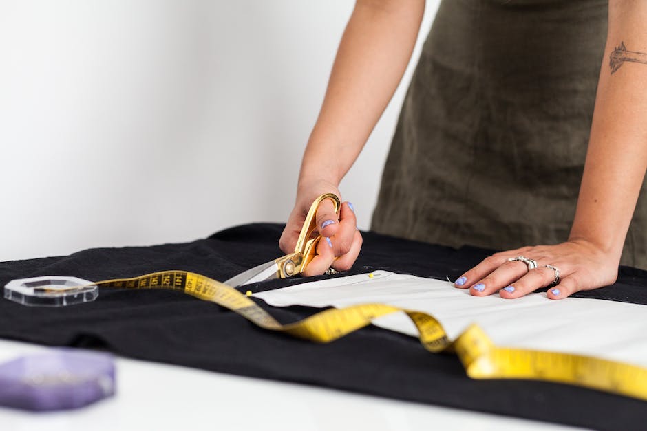 A person measuring fabric with a soft measuring tape for dressmaking